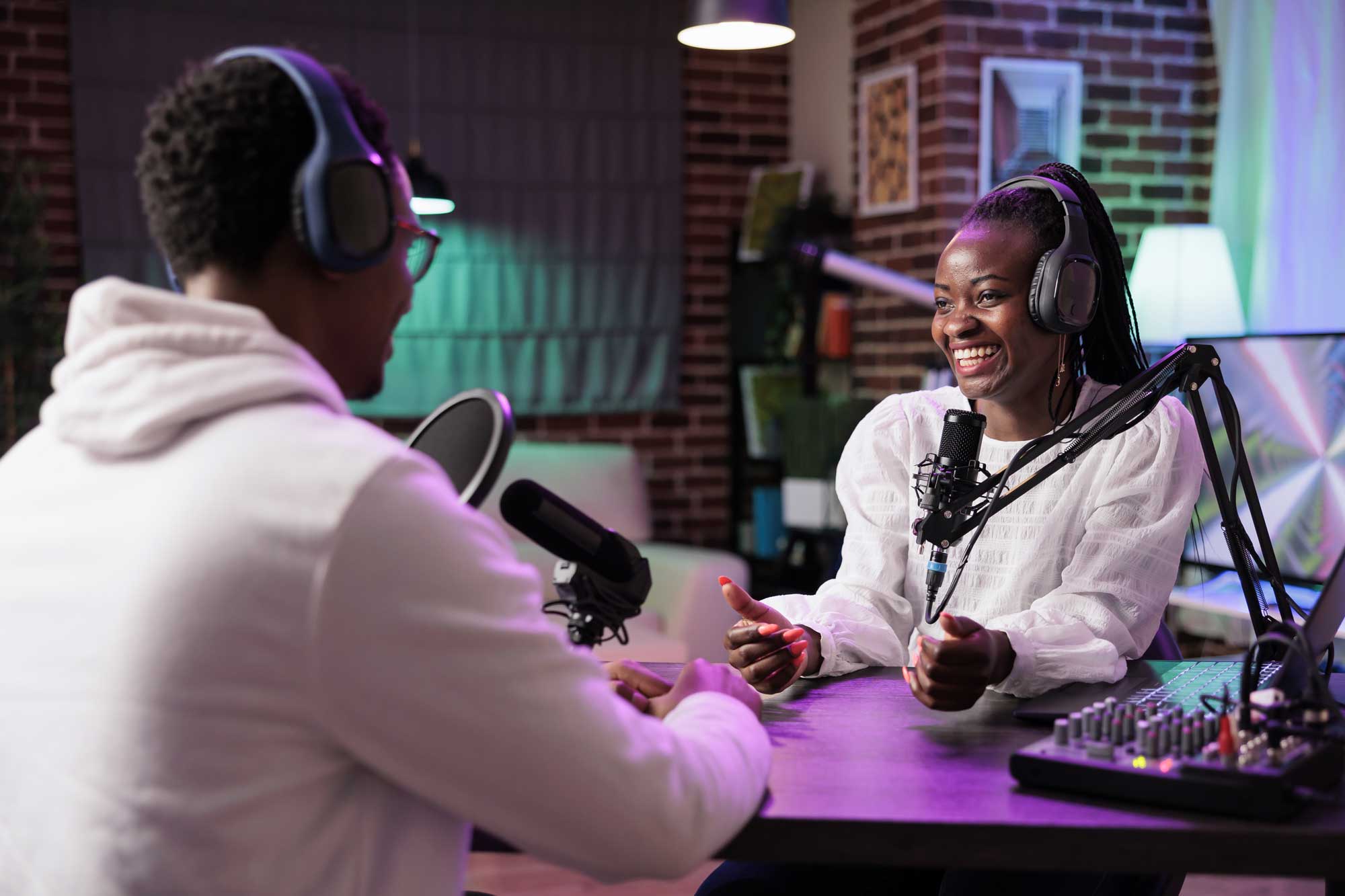 podcast-host-chatting-with-woman Two podcasters in studio